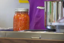 A jar of canned tomatoes in a kitchen