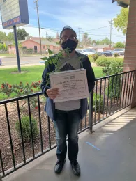 Parent graduate with University of California certificate of completion and garden kit.