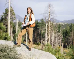 UCCE forestry advisor Susie Kocher stands on a rock surveying the landscape