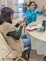Two women working on creating lavender wands.