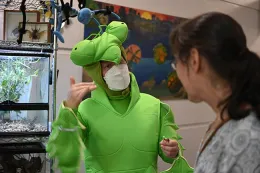 Tabatha Yang, Bohart Museum's education and outreach coordinator, dressed as a mantis for the open house. Here she answers questions about the insects in the live petting zoo, which include Madagascar hissing cockroaches and walking sticks. (Photo by Kathy Keatley Garvey)
