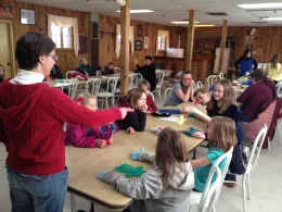 An adult showing youth how to sew little mosters. Photo: D. Blakey