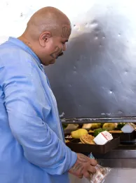 California State Prison Solano resident Ramon Tejeda receives his meal tray in the dining hall