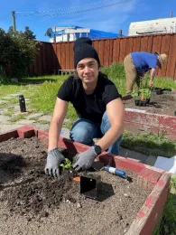 A resident works on planting seedlings in the garden bed