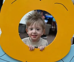 Logan Bantner peers through the bee cut-out that beekeeper Ettamarie Peterson borrowed from the Sonoma County Farm Bureau. (Photo by Kathy Keatley Garvey)