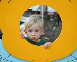 Is this how you do it? Kason Kelley poses for the camera behind the bee cut-out, brought by beekeeper Ettamarie Peterson. (Photo by Kathy Keatley Garvey)