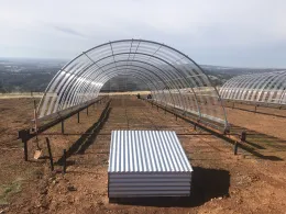 Movable 16'x50' green house structure that can be deployed over plots and reduce rainfall by 50%