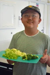 4-H youth member with chopped veggies on cutting board