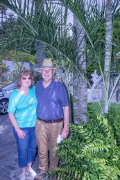 Judy and Bob Burtscher stand next to the stems of Dypsis burtscherorum in their garden, Fullerton, California. Hodel 3999 (type). © 2020 D. R. Hodel.