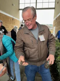 Man holding soil in his hand.