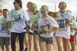 4-H youth smiling and running while covered in different colored powders