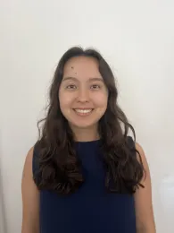 A woman in a dark blue shirt, with a white background