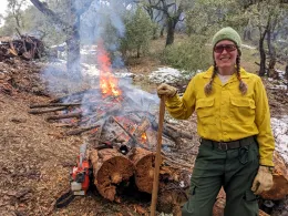 Barb Satink Wolfson in front of a pile burn.