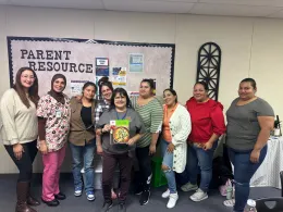 Adult EFNEP participants holding the cookbook used during lessons. 