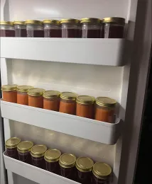 Inside of a freezer door, three rows of freezer jam in straight-sided glass jars with at least 1/2 inch of headspace