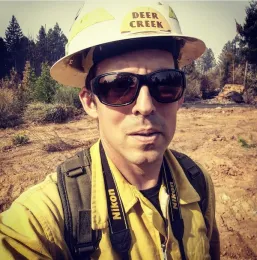Man in sunglasses yellow hardhat and jacket