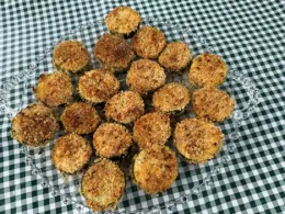Plate of breaded zucchini rounds on a green and white checkered tablecloth