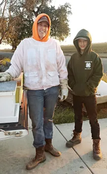 The Tremont 4-H'ers acquired their first bee colony from Breanna Wieferman of California Queen Bees, Woodland, shown here with new beekeeper and teen leader Ryan Anenson, (Photo by Sarah Anenson)