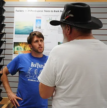 UC Davis entomology graduate student Jackson Audley talks to a visitor about bark beetle destruction. (Photo by Kathy Keatley Garvey)