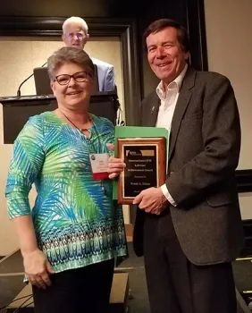 Frank Zalom, distinguished professor of entomology at UC Davis, receives his lifetime achievement award from Janet Hurley, the 2018 IPM Symposium Awards Committee. She is affiliated with Texas A&M University/AgriLife Extension. In back is George Norton, recipient of a lifetime achievement award in 2015. (Photo by Lena McBean, Remsberg Inc.)