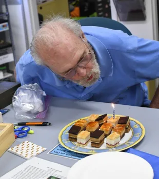 Robbin Thorp extinguishes the candle on the dessert. (Photo by Kathy Keatley Garvey)