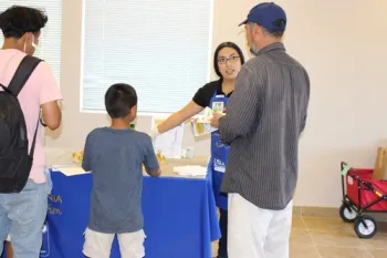 Community members visit the information booth to learn about choosing healthy snacks