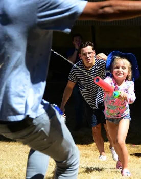 Lea Barnych, 4, whose mother Natalia Vasylieva is a researcher in the Bruce Hammock lab, takes aim, while French visiting student Valentin Nony (behind her) reacts. (Photo by Kathy Keatley Garvey)