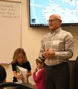 Ismail Seker's grandchildren Emre, 7, and Ruya, 4, assist him in his video presentation. Their father, Erkin Seker, is an associate professor in the UC Davis Department of Electrical and Computer Engineering. (Photo by Kathy Keatley Garvey)