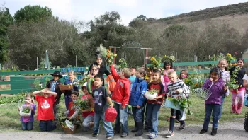 Class showcasing their freshly harvested produce.