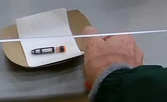 A vial containing saliva is deposited at a UC Davis testing kiosk. (Photo by Walter Leal)