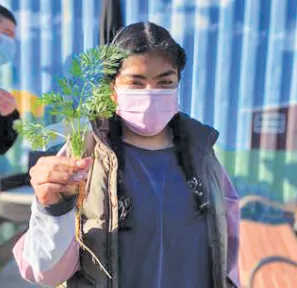 A student enjoys a carrot grown in a school garden.