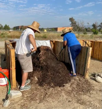Master Gardeners Bart K. and Elizabeth C. turning compost