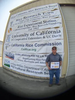 Aaron Alvarez, UC Davis graduate student, accepts D. Marlin Brandon Rice Research Fellowship award during the California Rice Field Day 2021.