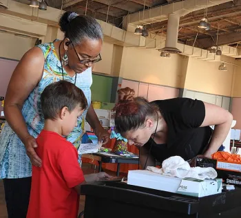 Brandon DeGroot encourages Iris Mayhew (left) of American Canyon and Ashley Traywick of Fairfield to look at and like the bug he collected outside McCormick Hall, Solano County Fairgrounds. (Photo by Kathy Keatley Garvey)
