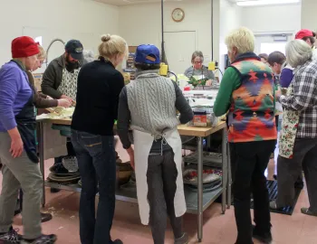 People gathered around a kitchen counter learning about food preservation (Photo: D Blakey)