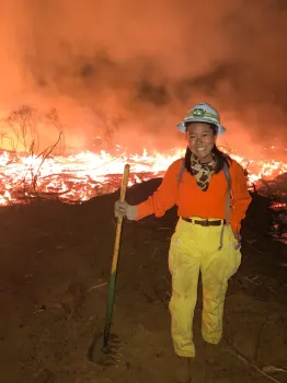 Katie Low standing in front of a prescribed fire