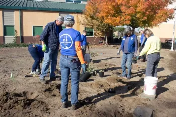 Four Master Gardeners digging and planting.