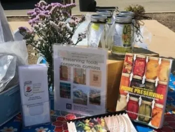Educational display table at a community event with food preservation materials