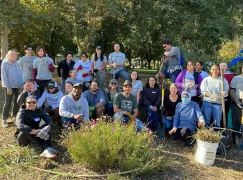 A group of volunteers pose for a photo in a garden