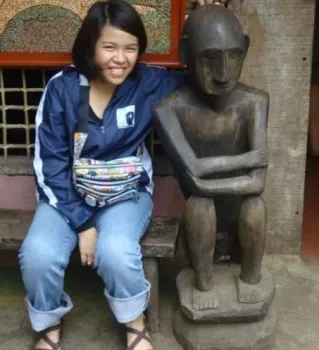 A young woman poses next to an 