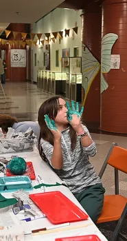 Skylan Potter,11, Sacramento, displays her hands--blue-green color from the color of her paper mache wasp nest. (Photo by Kathy Keatley Garvey)