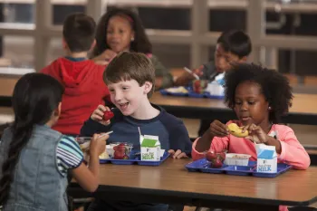Children in cafeteria eating school meals. Photo credit: USDA.