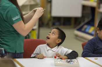 Boy looking up at adult holding something in her hands