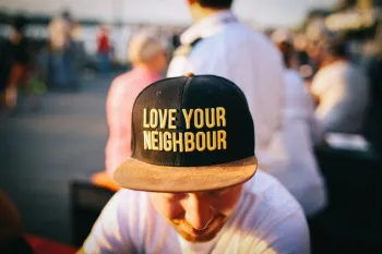 Man with hat that reads 'love your neighborhood'