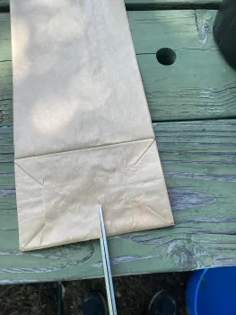 Photo showing how to cut the slit in the bottom of a paper bag.