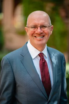 Ken Tate wearing a cabernet sauvignon-colored tie and gray suit
