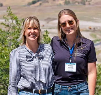 Two blonde women stand together