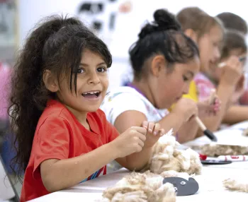 Children smiling in a classroom during a UC ANR program