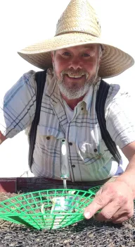 Max Fairbee wearing a hat and holding a green basket