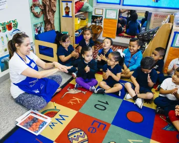Photo of a program staff member or teacher from an ANR statewide program interacting with children in a classroom setting